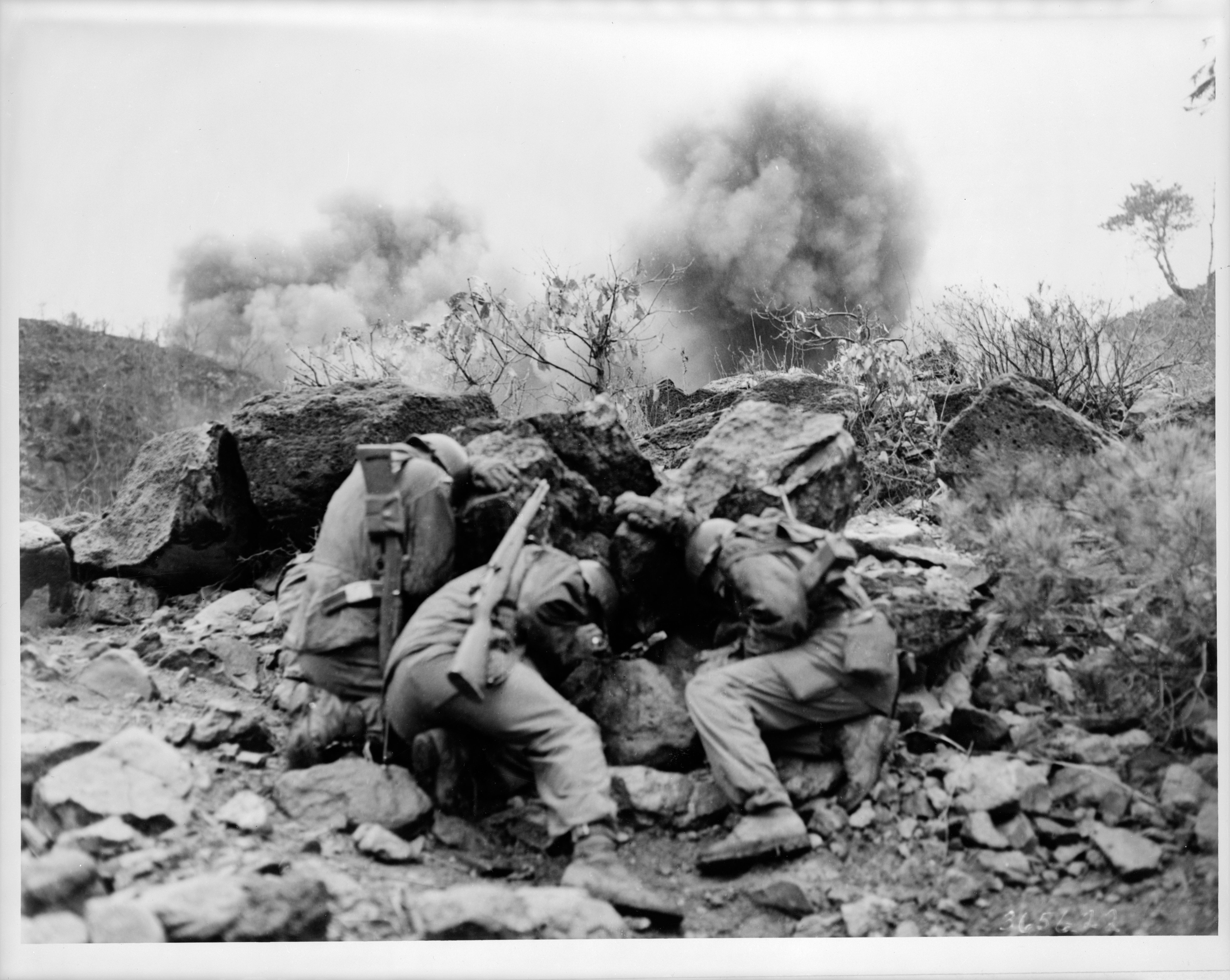 Men of the 35th Infantry Division take cover from exploding mortar shells near the Hantan River in central Korea in April 1951. Photo from the Library of Congress.