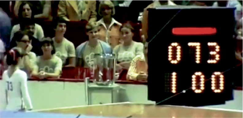 Nadia Comăneci and the audience in the Montreal Forum on July 18, 1976 all stare in disbelief at Nadia’s score of 1.00 for her opening performance on the uneven bars.